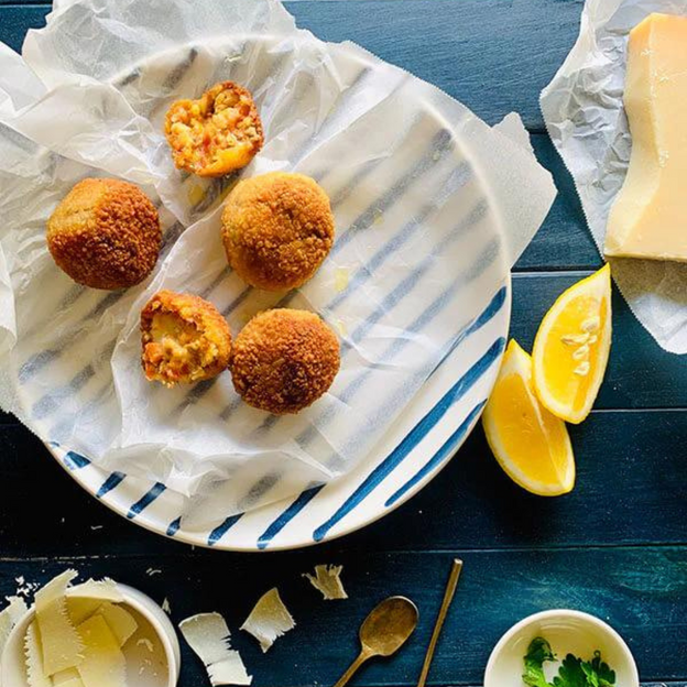Four Gluten-free, Low FODMAP (onion & garlic free) beef bolognese and mozzarella arancini on plate.