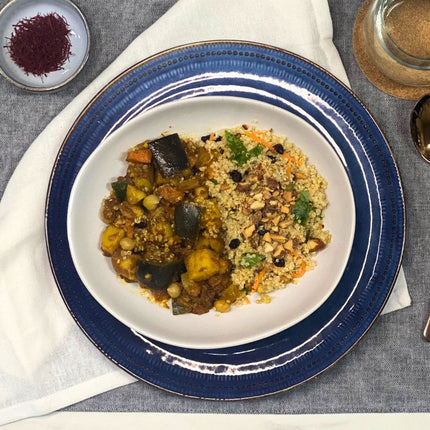 A plate of Moroccan vegetable stew with quinoa, garnished with nuts and herbs. Gluten-free, Low FODMAP  and vegan.