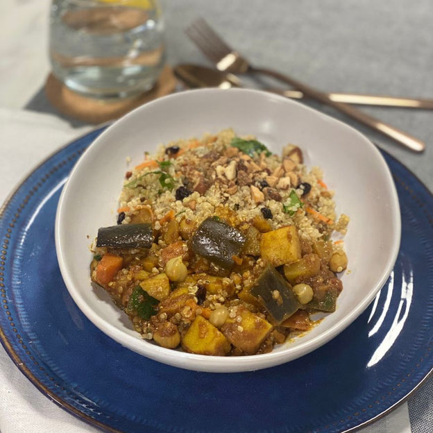 Gluten-free, Low FODMAP vegan Moroccan vegetable stew with almond and cranberry quinoa in bowl.