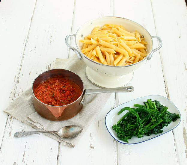 The Best Bolognese Sauce in a saucepan with pasta and broccolini on the side. We Feed You ready meal.