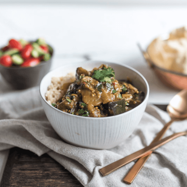 Tamarind Eggplant Curry w/ Cherry Tomatoes & Brown Rice in bowl.  This 375g serve is Gluten Free, lactose free and vegan.